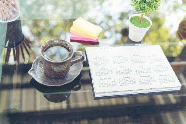 istock Calendar 2018 Appointments Schedule place on grass table with bohkeh and light on background. colorful post-it and cup of coffee for planner. 1010589848