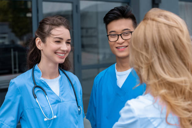 istock teacher talking with smiling multicultural students at medical university 1010598846