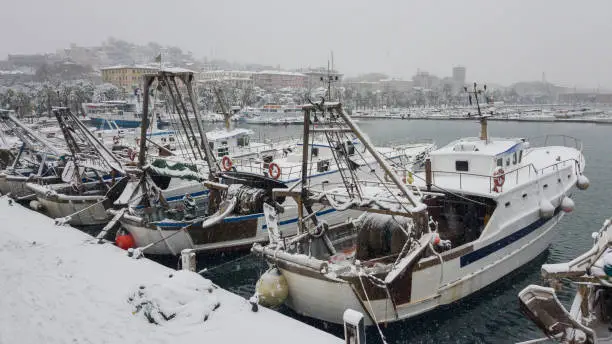 Photo of Professional fishing boats stand at the berth covered with snow