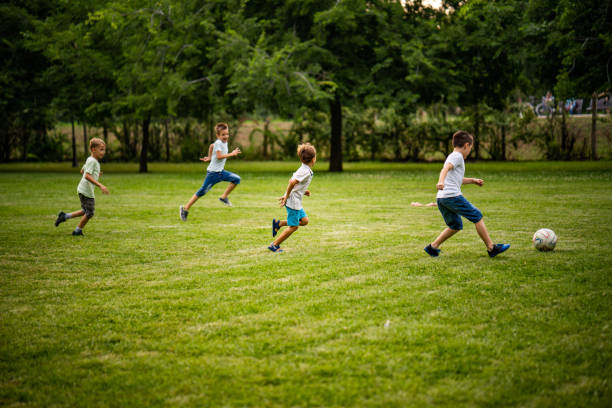 公園で少年サッカーします。 - 子供サッカー ストックフォトと画像
