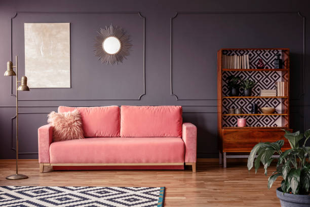 una pintura de mármol de color beige y un espejo de oro de sol sobre una pared gris con moldura en un elegante salón interior con terciopelo, polvo rosa sofá y muebles retro - cushion pillow textile luxury fotografías e imágenes de stock