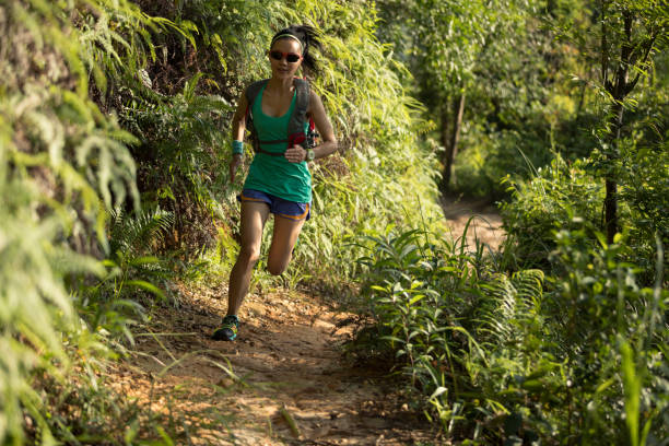 istock Woman trail runner running on sunny forest trail 1010614934