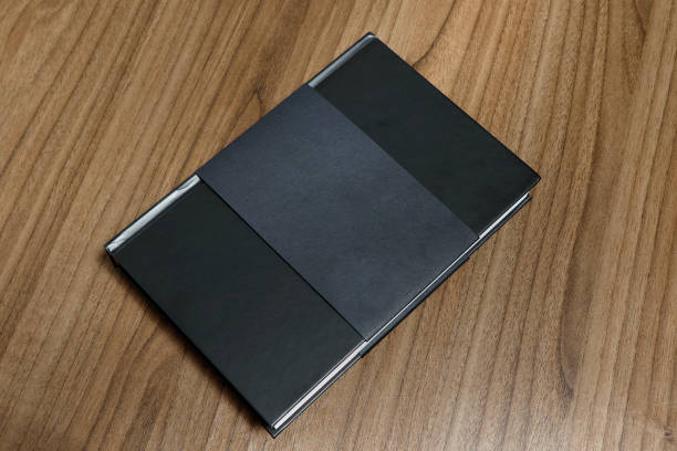 istock Black hardcover book with protector on wooden surface - mock-up black book 1010614994