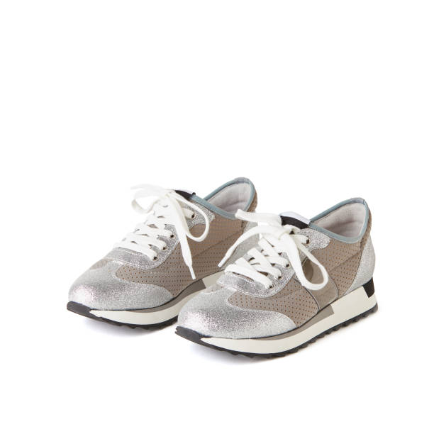 istock Glamorous silver and beige  sneakers. Studio shot, white background. 1010615360