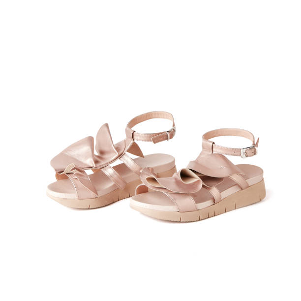 istock Elegant rose gold flat sandals with ruffles on top. Studio, white background 1010617832
