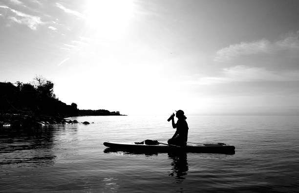 istock Man drinking water on paddleboard at sunrise 1010625374