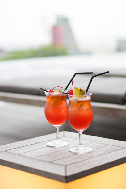 Red cocktail from Singapore, Asian inspired cocktail, Singapore Sling on a swimming pool.
