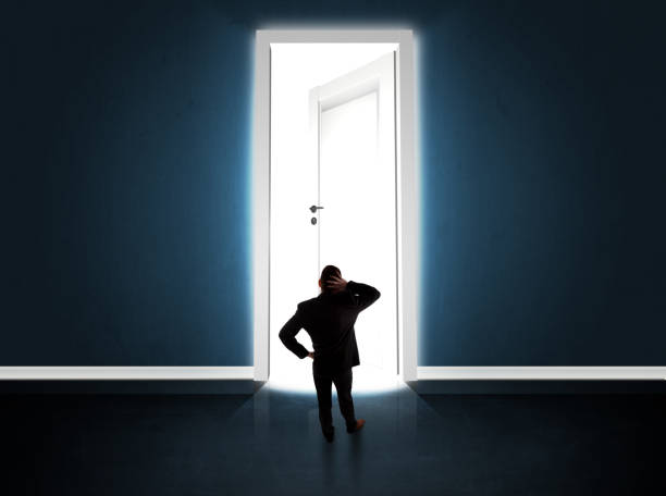 istock Business man looking at big bright opened door 1010631668