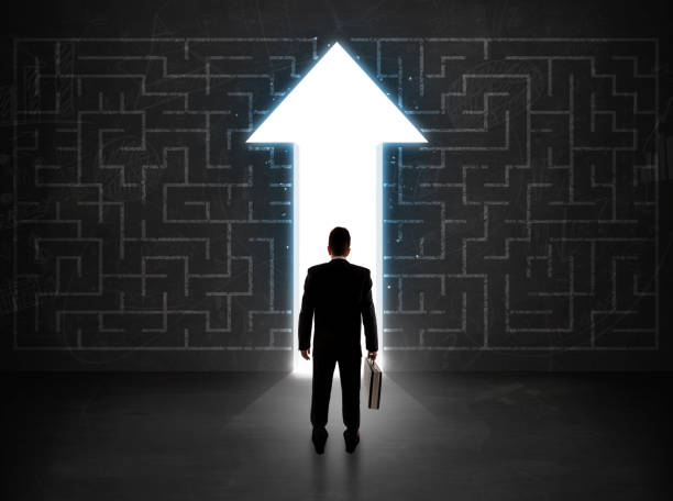 istock Business person looking at maze with solution arrow on the wall 1010631820
