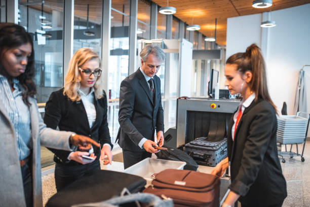 passeggeri in piedi accanto allo scanner di sicurezza in aeroporto - security staff security airport airport security foto e immagini stock