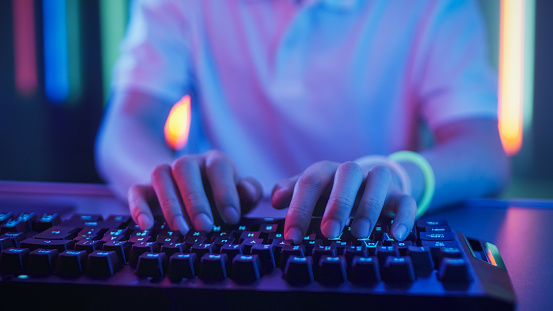 Close-up on the Hands of the Gamer Playing in the Video Game Using Keyboard. Hacker Breaks into System.