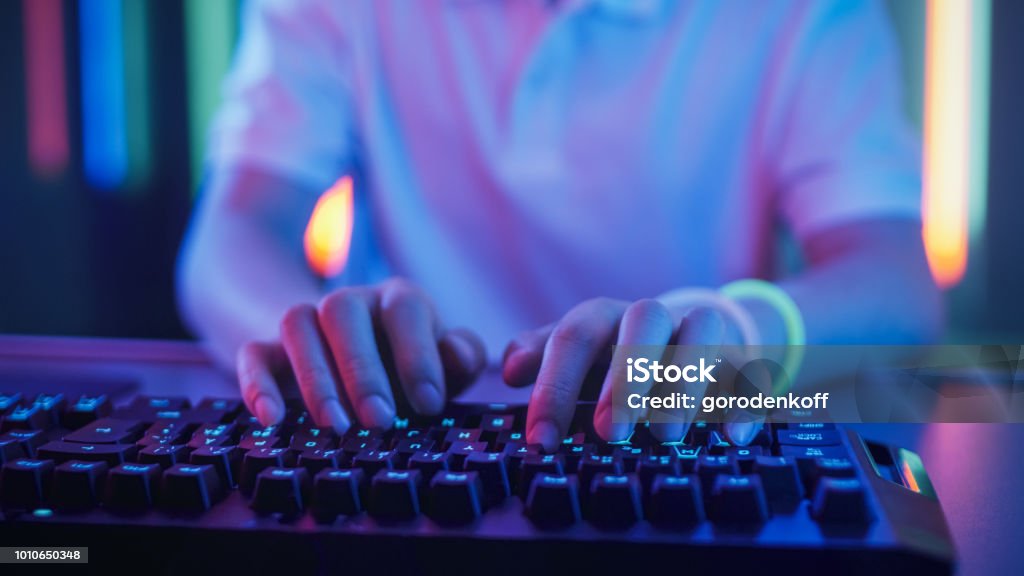 Close-up on the Hands of the Gamer Playing in the Video Game Using Keyboard. Hacker Breaks into System. Computer Keyboard Stock Photo