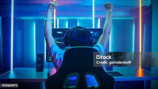 Professional Gamer Playing And Winning In Firstperson Shooter Online Video Game On His Personal Computer Footage Fade Out Into Bokeh Room Lit By Neon Lights In Retro Arcade Style Cyber Sport Championship Stock Photo - Download Image Now