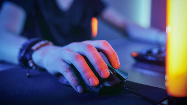 istock Close-up on the Hand that Uses Computer Mouse. Cool Neon Retro Lights. Browsing in Internet or Playing Online Games. 1010651414