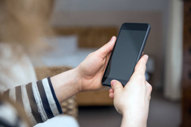 istock Woman is looking at a blank smart phone screen with copy space 1010652176