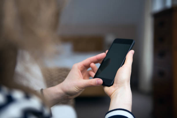 istock Woman is looking at a blank smart phone screen with copy space 1010652182