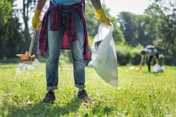 istock Man picking up plastic and paper litter in the park 1010655436