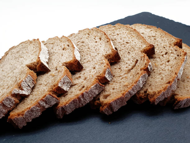 istock Sliced bread cropped on white background and slate plate 1010659064