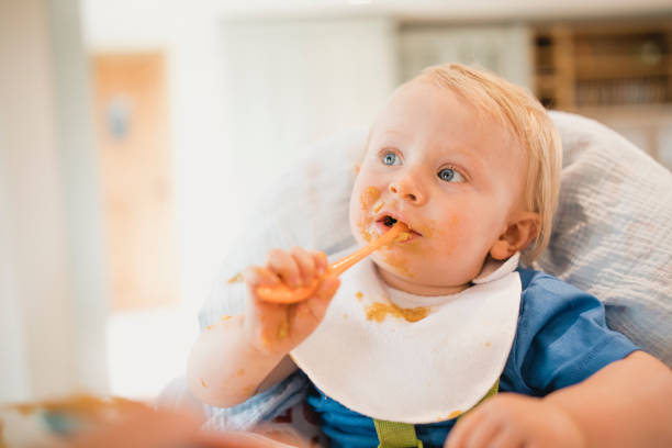 istock Baby Boy Eating In His High Chair 1010659630