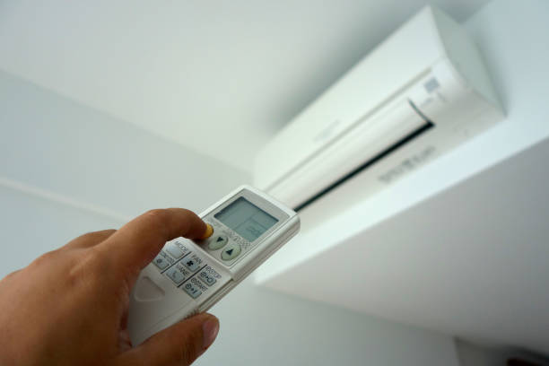 istock Hand holding remote control, turning on of air conditioning 1010660280