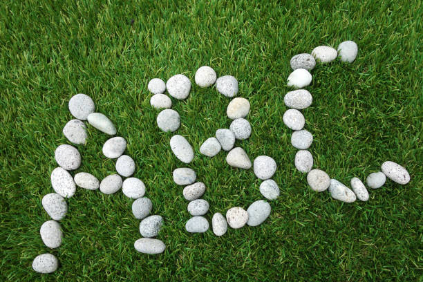 Letters A B C combined from white stones on green grass