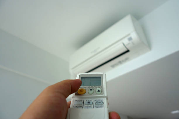 istock Hand holding remote control, turning on of air conditioning 1010665062