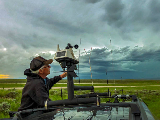 Storm-chaser adjusts the rooftop weather station on his chase vehicle as a severe storm builds in the background Legendary Aussie storm-chaser Clyve Herbert adjusts the rooftop weather station on his chase vehicle as a severe storm builds in the background storm chaser stock pictures, royalty-free photos & images