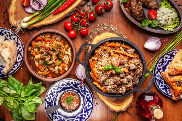 Traditional Uzbek oriental cuisine. Uzbek family table from different dishes for the New Year holiday. The background image is a top view. Traditional Uzbek oriental cuisine. Uzbek family table from different dishes for the New Year holiday. The background image is a top view. oriental food stock pictures, royalty-free photos & images