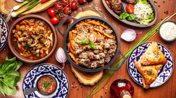 traditional uzbek oriental cuisine. uzbek family table from different dishes for the new year holiday. the background image is a top view. - típico oriental imagens e fotografias de stock