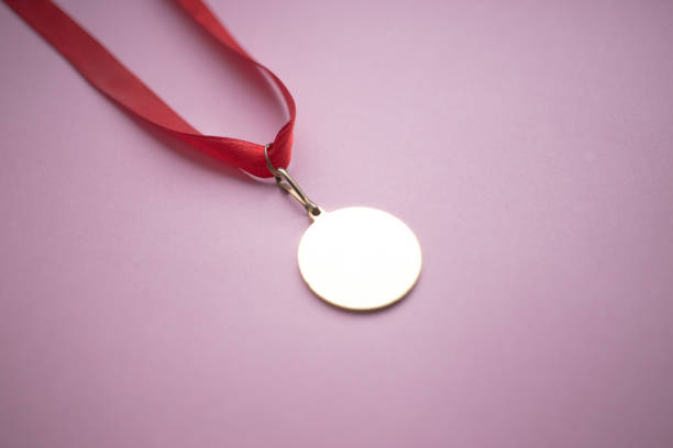 istock gold medal on a red ribbon on a pink background 1010681240
