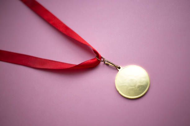istock gold medal on a red ribbon on a pink background 1010681248