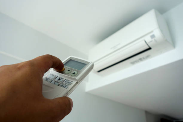 istock Hand holding remote control, turning on of air conditioning 1010687472