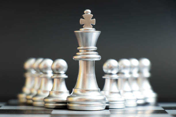 istock Silver king chess piece stand in front of pawn on black background (Concept of leadership, management) 1010726340