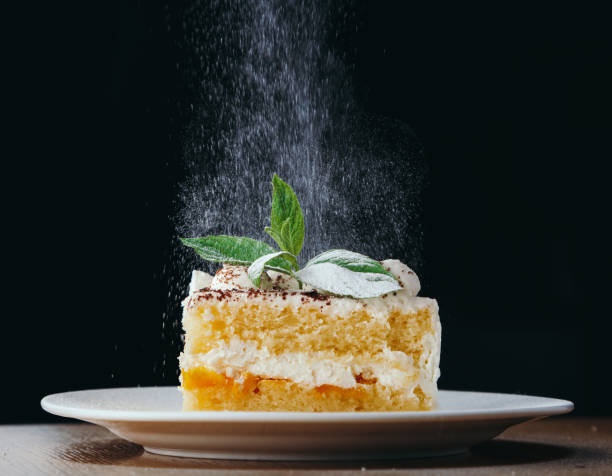 istock piece of Biscuit cake with white cream decorated with mint and powered sugar 1010733230