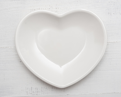 Heart shaped plate on a wooden background