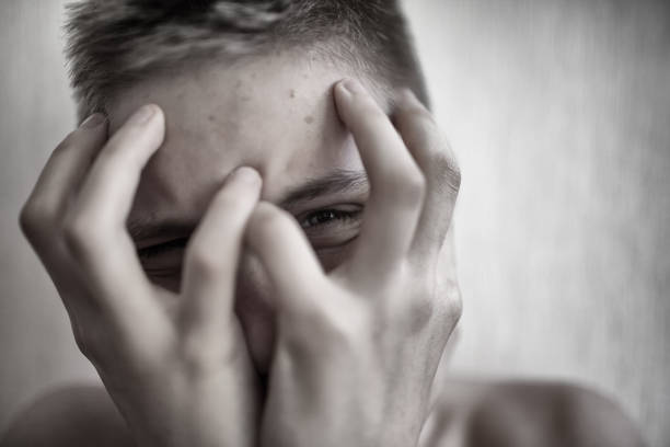 istock Boy teenager covers his face with his hands 1010745756