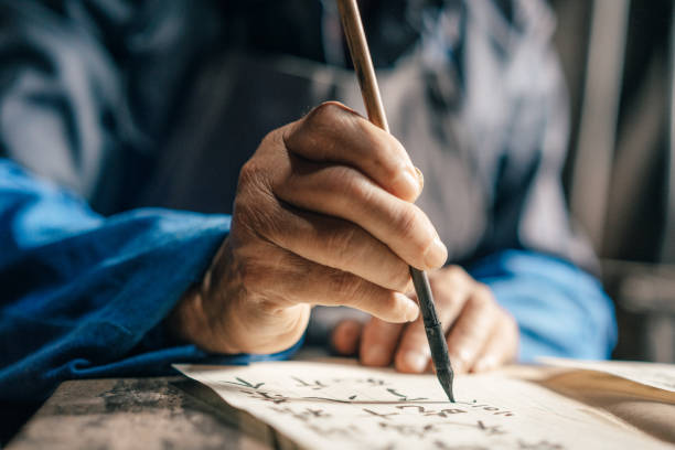 старые руки человека, пишущего китайский сценарий - - китайский шрифт стоковые фото и изображения