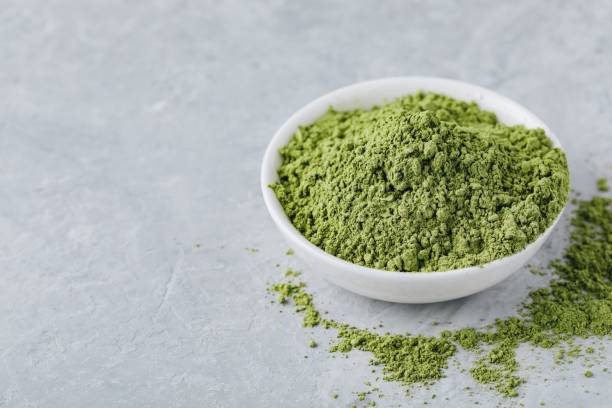 istock Green matcha tea powder in white bowl 1010754108