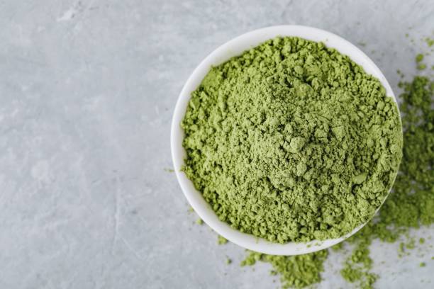 istock Green matcha tea powder in white bowl 1010754616