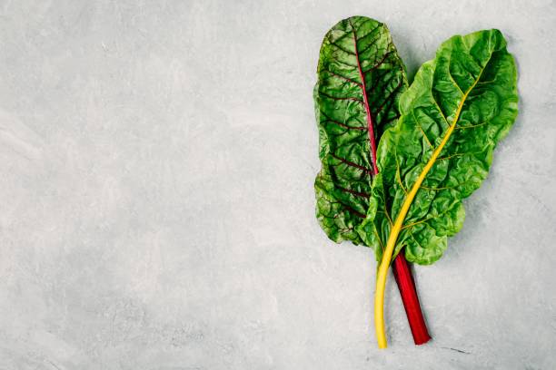 istock Fresh raw swiss rainbow chard leaves on gray stone background. 1010755194