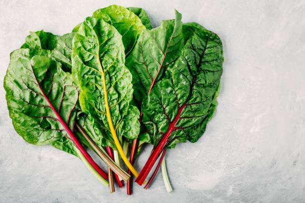 istock Fresh raw swiss rainbow chard leaves on gray stone background. 1010755340