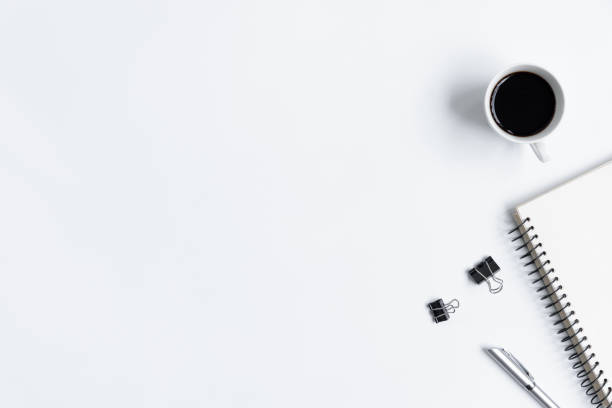 istock White office desk table and equipment for working with black coffee  in top view and flat ray concept. 1010759636