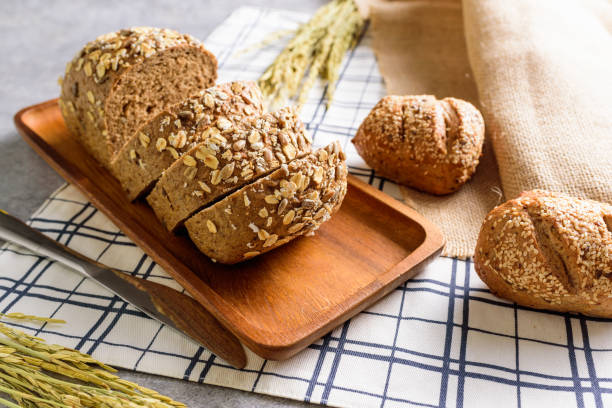 Homemade Whole Wheat Rye Bread Loaf is cut and placed on a wooden plate.And put on a tablecloth.