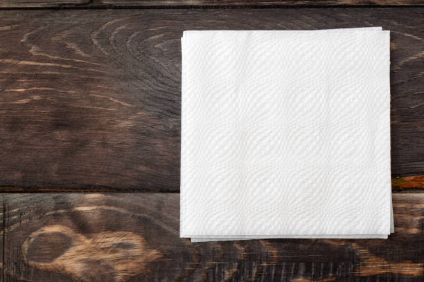 Paper  napkins on wooden surface White paper napkins on dark wooden table surface napkin stock pictures, royalty-free photos & images