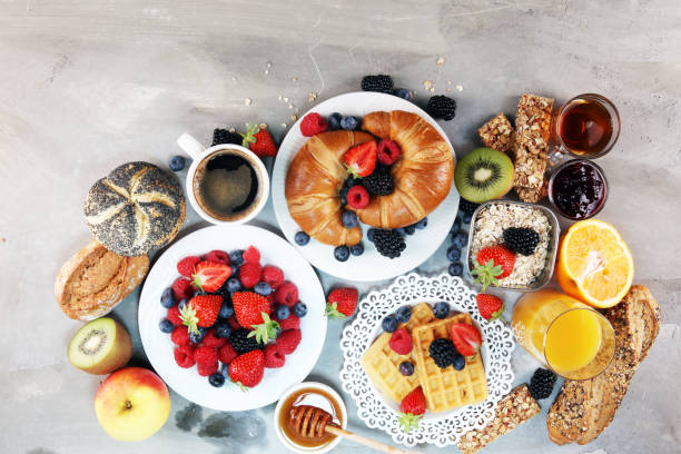 istock breakfast on table with waffles, croissants, coffe and juice. 1010799940