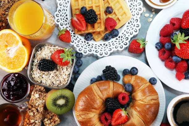 istock breakfast on table with waffles, croissants, coffe and juice. 1010813356