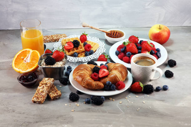 istock breakfast on table with waffles, croissants, coffe and juice. 1010814070