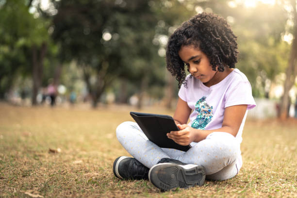 istock Little Cute Girl Using Tablet at Park 1010828634