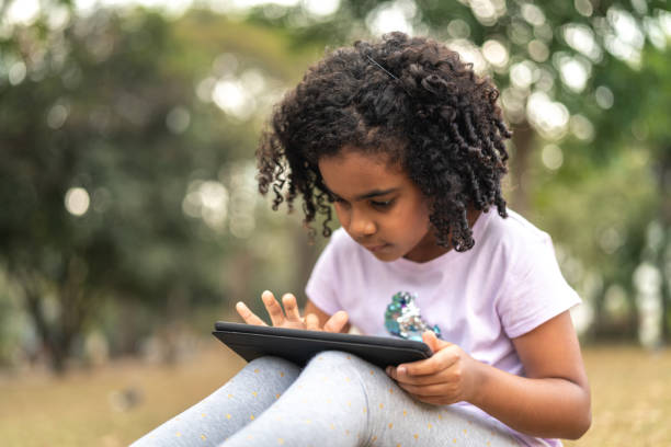 istock Little Cute Girl Using Tablet at Park 1010831186