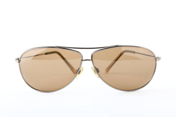 istock Single scratched old classic sunglasses with metal frame and brown lenses on a white background 1010835814